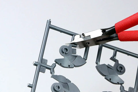 Precision Model Nippers For Plastic Miniatures cutting plastic part from sprue, featuring single edged snips with flat thin blades.