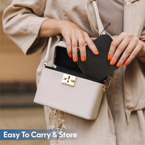 Person placing a heart-shaped item into a beige box-shaped bag, showing portability for Must Have Carry Along Portable Sewing Kit With Mixed Color Threads.