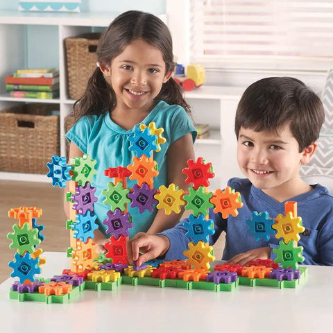 Children playing with Gears 100-Piece Deluxe Building Set For STEM Fun, Fine Motor Play And Creative Discovery on a table.