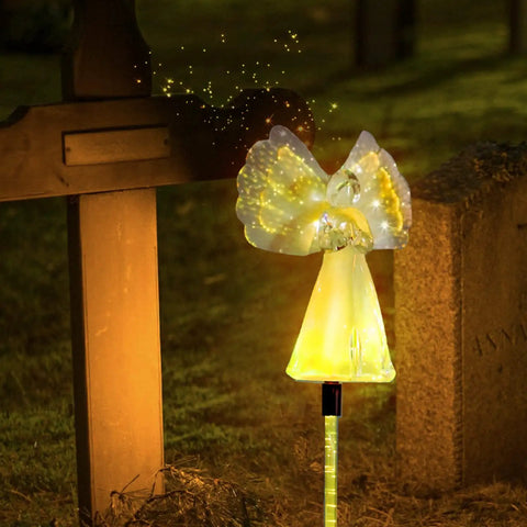 Two Pack Outdoor Solar Garden Lights With Color Changing LEDs, IP67 Waterproof Angel Decor Stakes illuminating a cemetery grave.