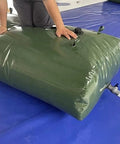 Person using Foldable Water Storage Bladder With Faucet Beast 540L Portable Tank for outdoor adventures on blue surface