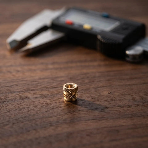 Premium 48Pcs Brass M4 Heat Set Threaded Inserts For 3D Printing With Knurled Design on wooden surface with caliper.