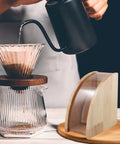 Sweet Wooden Coffee Filter Holder Box Fan Design Compact Countertop Storage Organizer For Hand Drip Brewing, placed beside pour over setup.