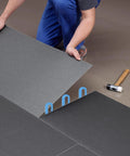 Three blue plastic horseshoe tile shims (U-shaped) for leveling ceramic floor tiles.