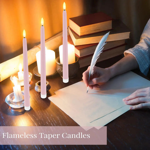 Person writing near pink 11-inch LED flickering flameless taper candles with books, showing realistic candlelight for decor.