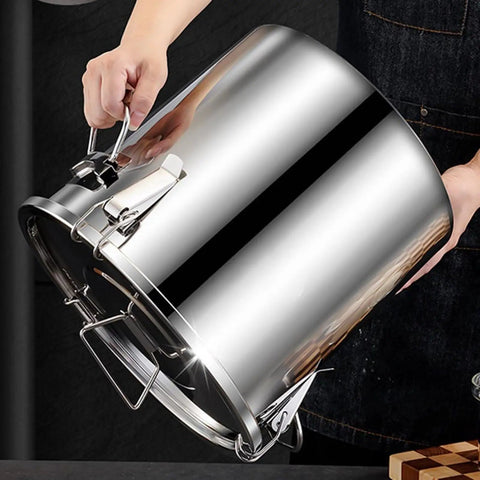 Hand holding Premium Heavy Duty 304 Stainless Steel Airtight Grain Storage Bucket, showcasing its latches and shiny finish.