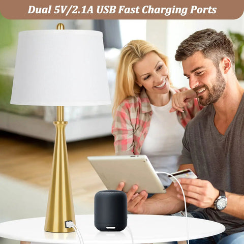 Two Dope Gold Table Lamps With USB Ports And Rotary Switch, 26 Inch Tall Brass Nightstand Lamps With White Fabric Shade next to couple