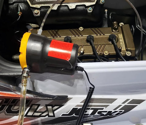 Portable 12V 60W Oil Extractor Pump For Fluid Changes shown in use on a jet ski engine, illustrating the grab-and-go design.