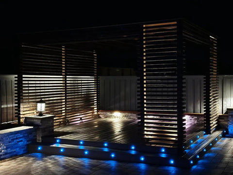 Low Voltage Blue LED Deck Lights Kit With 20 Waterproof Recessed Lamps illuminating a wooden pergola on a patio at night