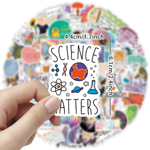 Hand holding sticker from 100 Piece Science Stickers Pack For Chemistry Biology Physics Nerds showing planet and science icons.