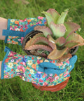 Woman wearing Womens Gardening Gloves With Printed Design And Touchscreen Grip For Thorn Proof Puncture Resistant Work Gloves For Weeding Planting Pruning And Daily Garden Tasks For Everyday Use holding a potted plant.