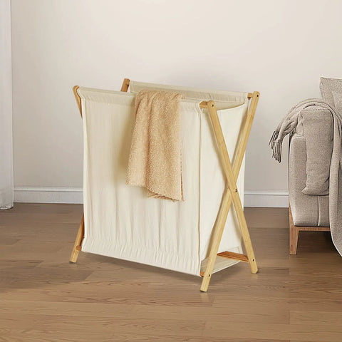 Collapsible Bamboo Wood Laundry Hamper With X Frame Foldable Laundry Basket And Linen Canvas Bag, 50L, in a bedroom setting.