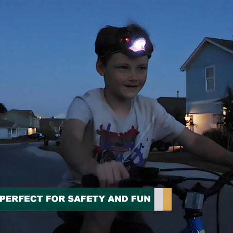 Child riding a bike at night wearing a Totally Rad LED Dinosaur Headlamp For Kids With Roar Sound And 3 Lighting Modes T Rex Shape Toy Flashlight