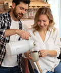 Man pouring coffee into mug using Thermal Stainless Steel Coffee Carafe With Double Wall Vacuum Insulation 68 Ounces Heat And Cold Retention Beverage Dispenser BPA Free SUS304 18 8 Steel White Gold Finish Office And Home Use Party Ready