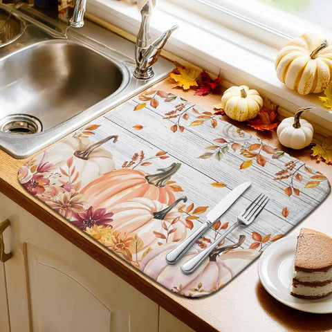 Fall Thanksgiving Dish Drying Mat With Pumpkin Leaves Floral Design Absorbent Microfiber Surface Thick Cushioned Pad Machine Washable 18 By 24 Inches Cozy Fall Vibe For Your Kitchen Counter Pad displayed by a sink with pumpkins and leaves