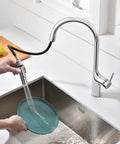 SUMERAIN Kitchen Faucet with Pull Down Sprayer Dual Mode Brushed Gold in action washing a teal plate over a sink.