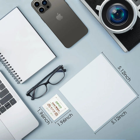 Front view of 200-count lens wipes packet for eyeglasses beside black glasses on a blue desk.