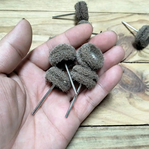 Hand holding 48 Piece Rotary Tool Buffing Wheel Set With Three Thirty Second Inch Mandrels And 2.35 Mm Shanks, shown up close.