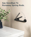Pivoting Double Post Toilet Paper Holder Wall Mount in Matte Black Stainless Steel on bathroom wall next to sink and plant