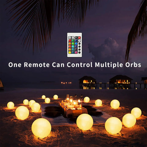 LED Glowing Ball Light Cordless 8 Inch with 16 Color Changing Options illuminating beach dinner setup at night