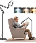 Man using Floor Magnifying Glass With Light And Stand, 10X To 20X Magnification, 72 LED Lamp for reading in an armchair
