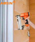 Ultra Lightweight Pneumatic Pin Nailer For Custom Woodworking held against wood panel, showing featherweight aluminum build and slim nose.