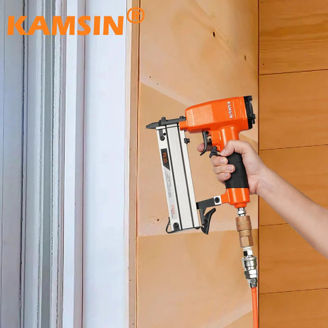 Ultra Lightweight Pneumatic Pin Nailer For Custom Woodworking held against wood panel, showing featherweight aluminum build and slim nose.