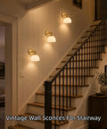 BELVM Vintage Milk Glass Wall Sconce Set of 2 - Gold Bathroom Wall Lights on a stairway wall for warm illumination.