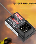 Close-up of Flysky FS-R4B 2.4GHz 4CH Receiver with ANT Protocol and single antenna PWM output against blurred background.