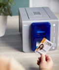 Single Sided Id Card Printer Boasting Quick Full Color Pvc Badge Printing With Smooth Lcd Touchscreen Navigation No Sweat Desktop Layout For Small Teams Crushing Daily Pass Creation Goals with PVC badge in hand.