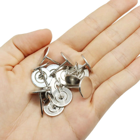 50 Piece Flat Head Thumb Tacks With Slick Silver Finish Heavy Duty Solid Steel Push Pins in a hand for easy handling.