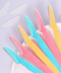 Six Piece Eyebrow Razor Kit For Her Or Him Is A Total Game Changer That Works Like Magic To Strip Facial Hair And Dermaplaning Skin While The Snug Cover Keeps Your Routine Easy Peasy And Always Clean. Colorful shavers with protective covers arranged in a row on a light background.