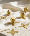 Solid Brass Gold Cabinet Knobs 4 Pack With Star Backplates on fabric, brushed brass finish, shown uninstalled for kitchen cupboard and dresser.