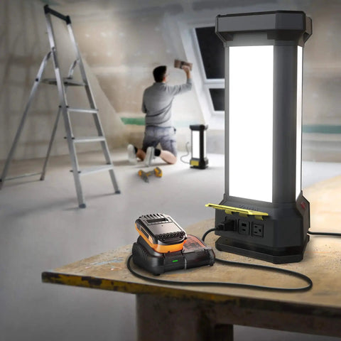Tower Work Light Delivers 9000 Lumen Brightness With Full 360 Degree Illumination, Three Dimmable Panels, Two 120V Outlets And USB A Port For Tools, Projects, And On The Job Site Lighting, illuminating a workshop with a man sanding in the background.