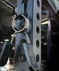 Close-up of Squat Rack Hooks And Power Rack Attachments For DIY Storage with barbell collars on 1 inch hole-spaced rack (Black).