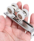Top Notch Two Piece Stainless Steel Barn Door Roller Hardware With Foolproof Wall Mounted Track And Heavy Duty Wheels For Tight Rooms And Hassle Free Install, showcasing durable roller wheels in hand.
