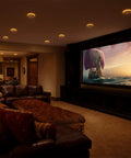 Cozy living room featuring a home theater setup illuminated by 12 Pack 6 Inch LED Recessed Ceiling Downlights With Adjustable 5CCT Color Temperature And Super Smooth Amber Night Light White Trim IC Rated No Sweat Installation.