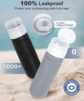 Must Have 20 Pack Travel Toiletry Bottles Set With Leakproof Silicone Containers TSA Approved showing black and gray bottles on sand.