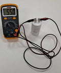 55 MFD Garage Door Opener Capacitor Fits New K030B532-1 and K030B532 250V Rating Plus Minus 5 Percent shown with multimeter