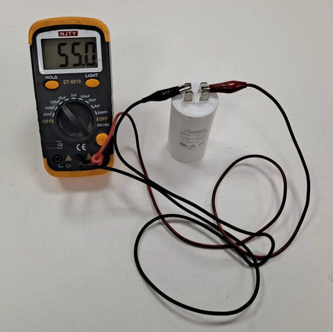 55 MFD Garage Door Opener Capacitor Fits New K030B532-1 and K030B532 250V Rating Plus Minus 5 Percent shown with multimeter