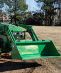 5 Foot Dirt Bucket Attachment For Tractors That Fits John Deere Hook And Pin Tractors in a field, attached to green tractor