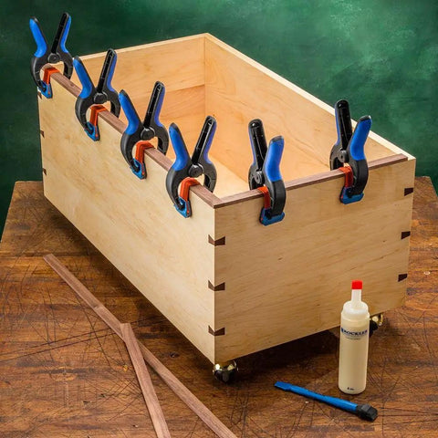 Medium Bandy Clamps Set For Woodworking With Easy Squeeze One Handed Operation clamping a wood box edge on a workbench