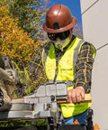 Worker wearing tinted safety goggles with anti fog lens for pro grade eye protection, ANSI Z87.1 plus, operating machinery outdoors