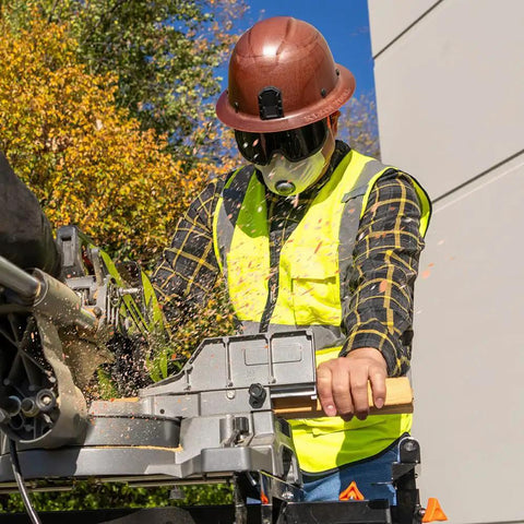 Worker wearing tinted safety goggles with anti fog lens for pro grade eye protection, ANSI Z87.1 plus, operating machinery outdoors