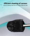Compact Toilet Brush With Stainless Steel Handle And Hidden Base cleaning under rim of a toilet, black bristles, close-up view.