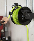 Manual Open Face Air Hose Reel 1/4 Inch By 100 Feet Hybrid ZillaGreen mounted on wall, showing hose layering guide in use