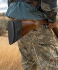 Hunter holding rifle with silicone recoil pad, "Beef Up Your Aim With This Gun Butt Stock Recoil Pad For Hunting And Shooting Black Silicone Cushion" visible