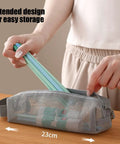 Travel Toiletry Bag With Ventilated Mesh Storage Ultra Portable Road Trip Ready in gray being opened on a table.