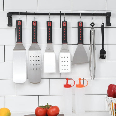 28 Piece Griddle Gear Kit For Blackstone Flat Top Grill Spatulas Scraper Turners hanging with squeeze bottles in kitchen setting.