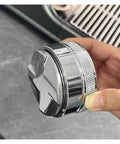 Close-up of Prime Pick 58Mm Espresso Coffee Distributor And Adjustable Palm Tamper, stainless steel with cushioned grip, held in hand.